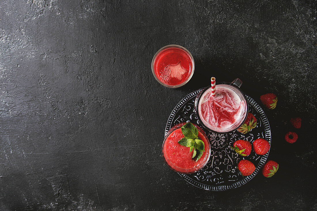 Drei verschiedene rote Fruchtsmoothies mit Erdbeere, Wassermelone und Granatapfel