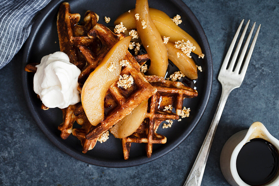 Waffles on plate with pears and whipped cream
