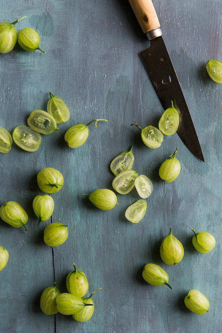 Gooseberries being chopped on a blue background