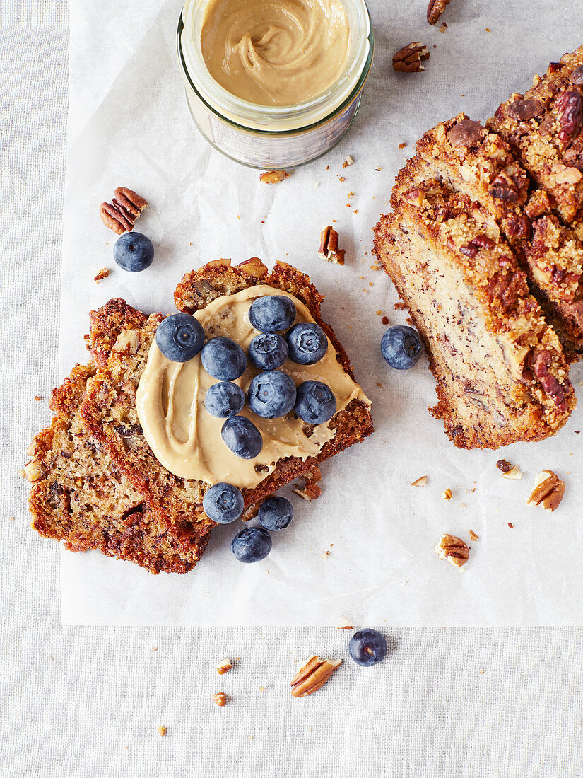 Loaf of banana bread with nut butter and blueberries