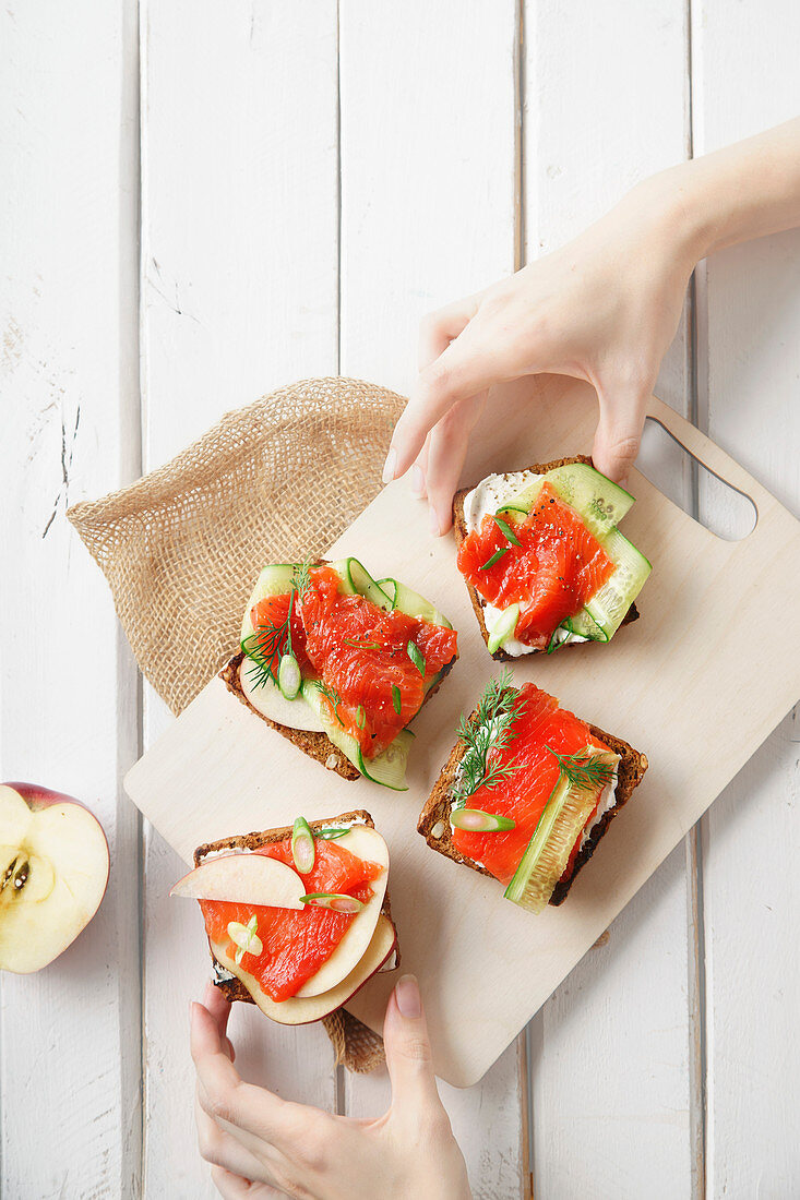 Danish traditional snack smorrebrod with salmon, cucumbers and cream cheese