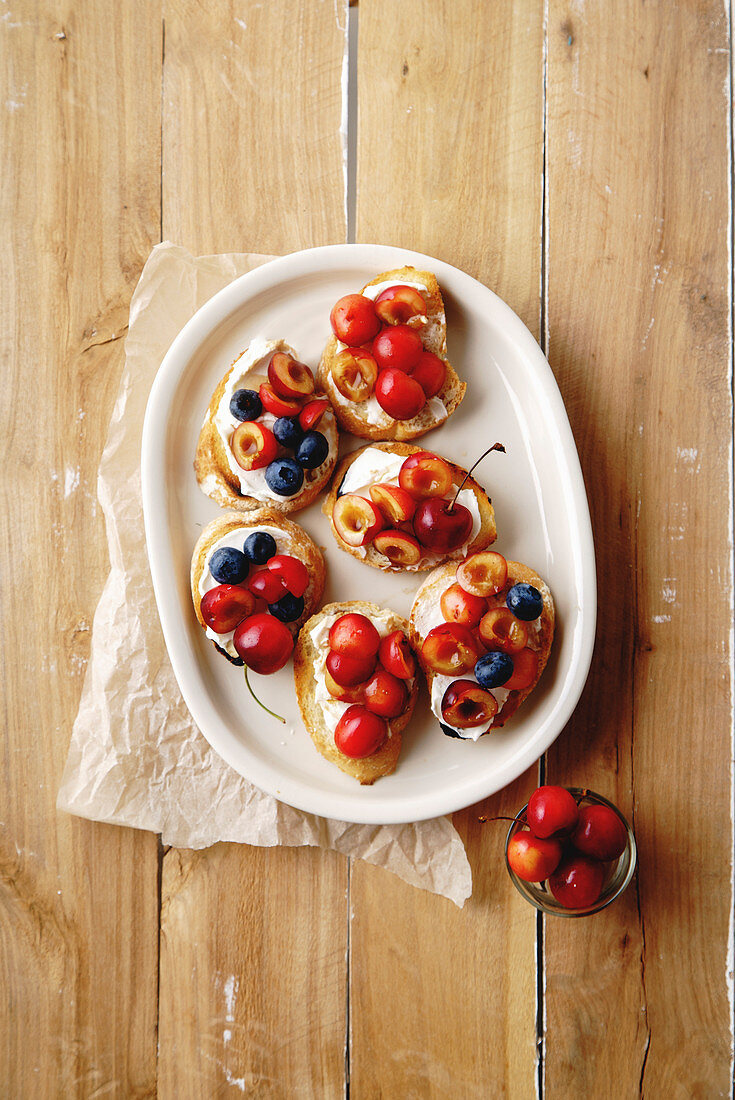 Süsse Bruschettas mit Früchten, Frischkäse und Honigsauce (Aufsicht)