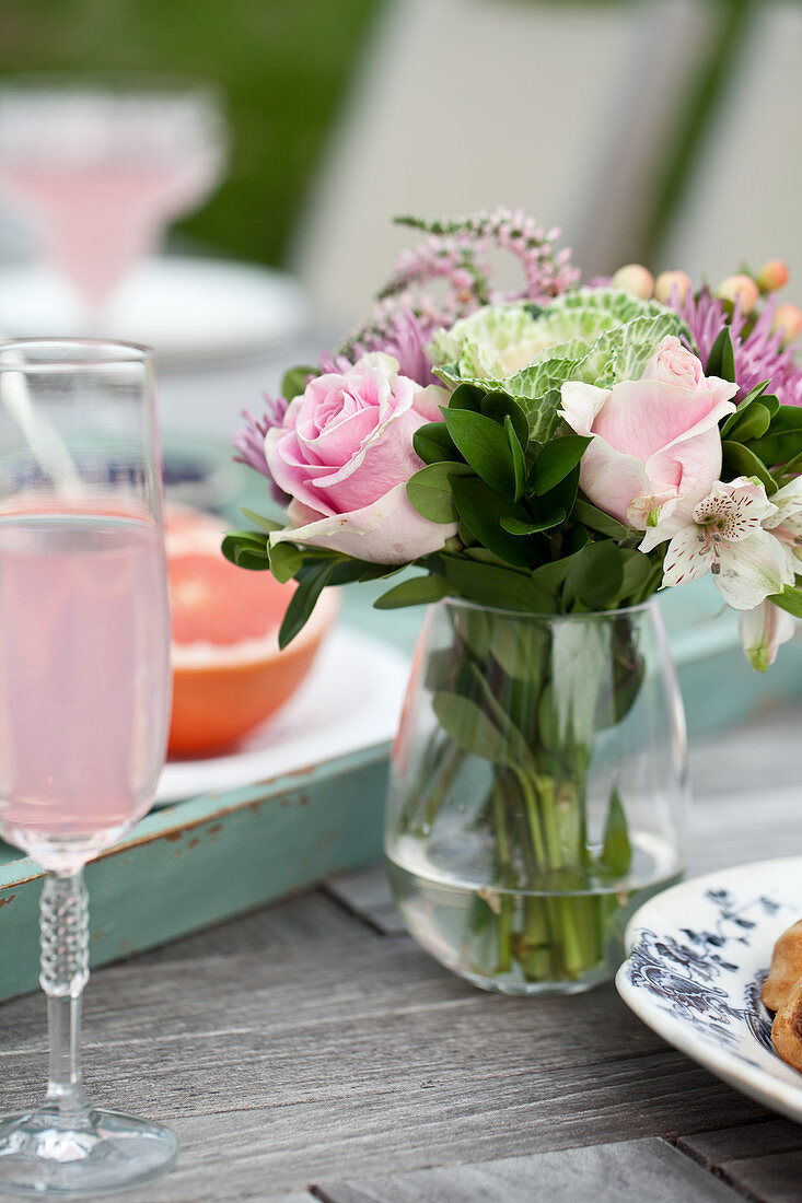 Gedeckter Tisch zum Brunch mit Blumen, rosa Limonade und Grapefruithälften