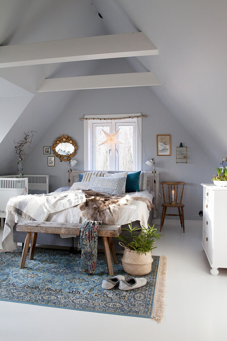 Doppelbett, Babybett und rustikale Holzbank im Dachgeschoss-Schlafzimmer