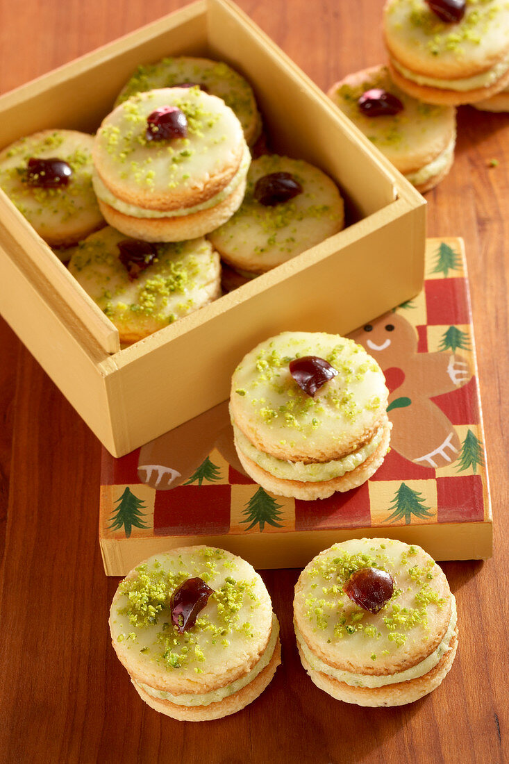 Mozart turrets (shortbread cookies with pistachio cream, icing and Amarena cherries)