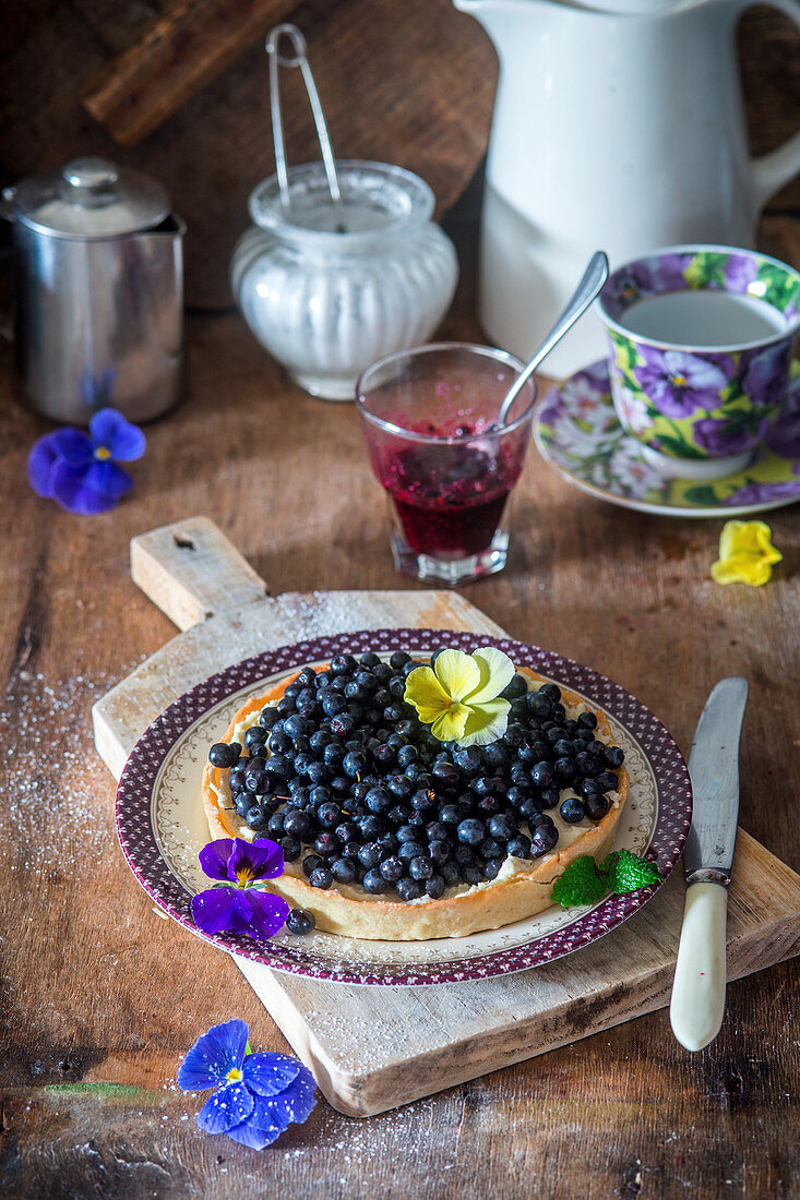 Blueberry tart decorated with edible flowers