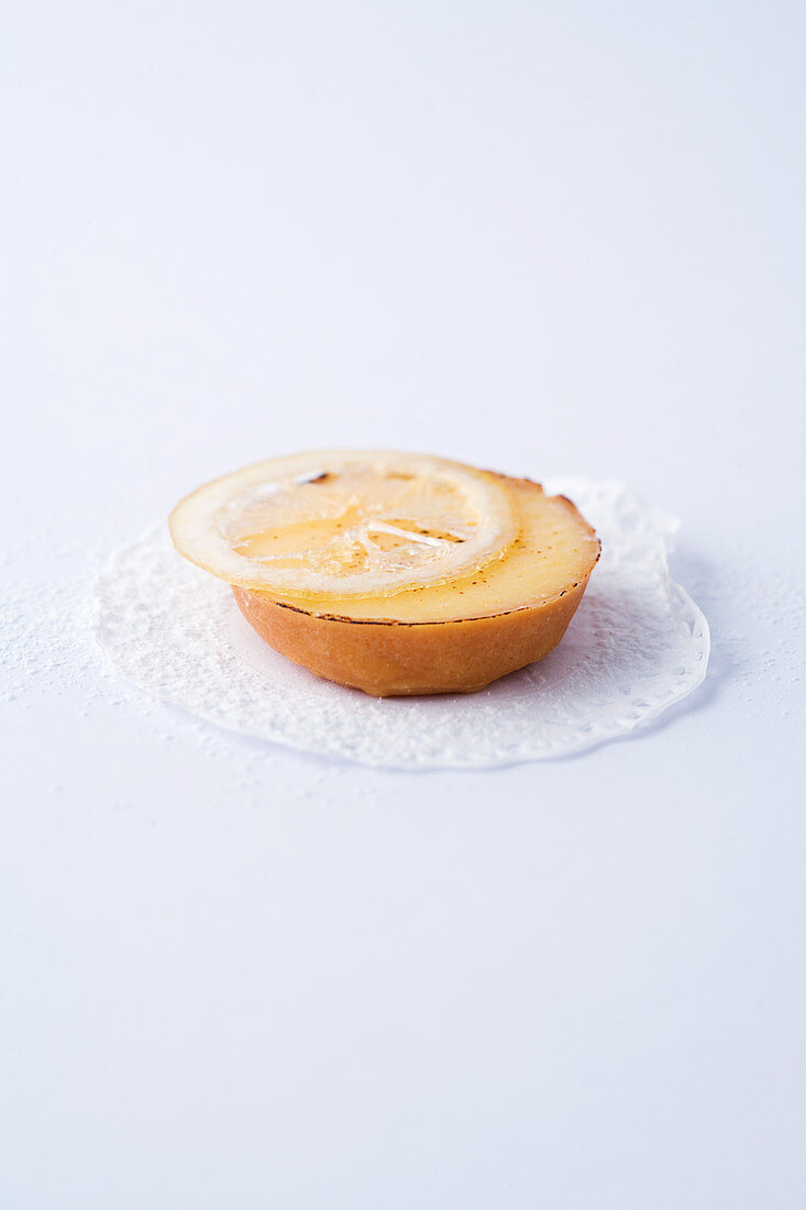 Ein Mini-Tartelett mit Zitronencreme vor weißem Hintergrund