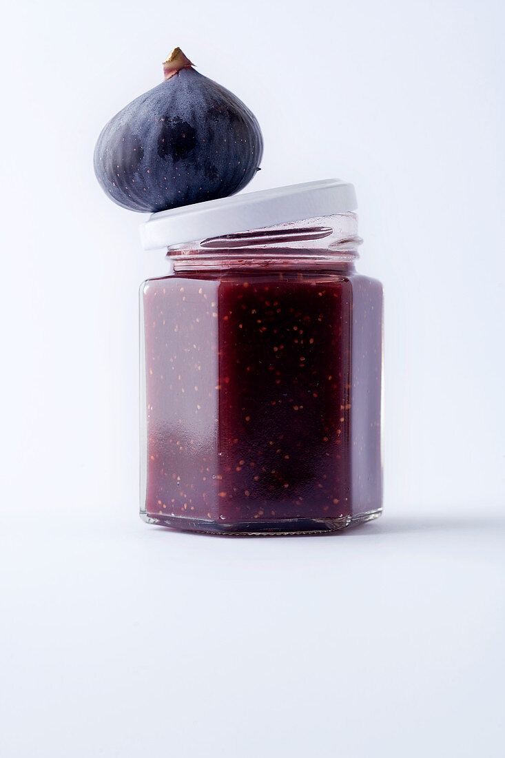 A jar of fig jam against a white background