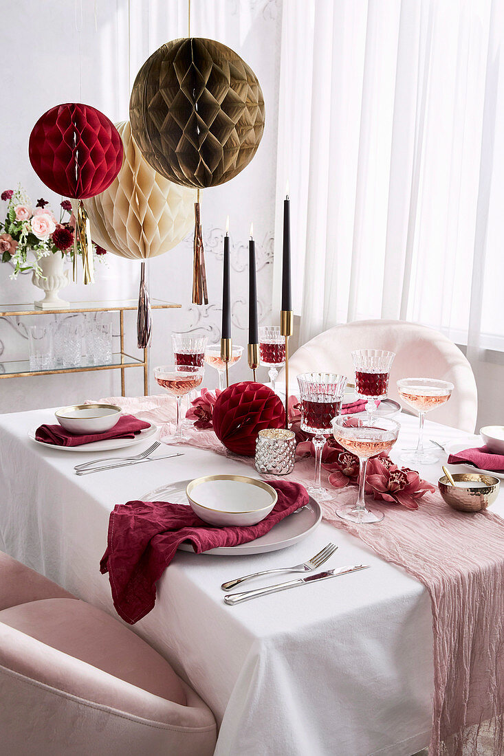 Festive table in pink and white with honeycomb balls as decoration