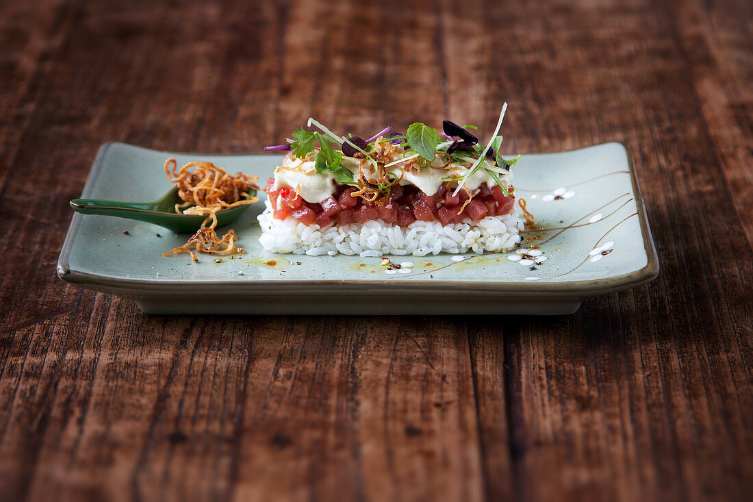 Tuna tartare on sushi rice with wasabi and soya foam and fried shallots