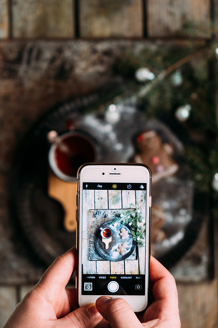 A photo from a phone with a photo from a cup of tea and Christmas cookies