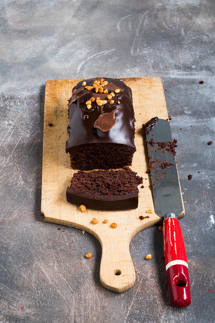 Chocolate cake on a wooden plank on a grey backdrop