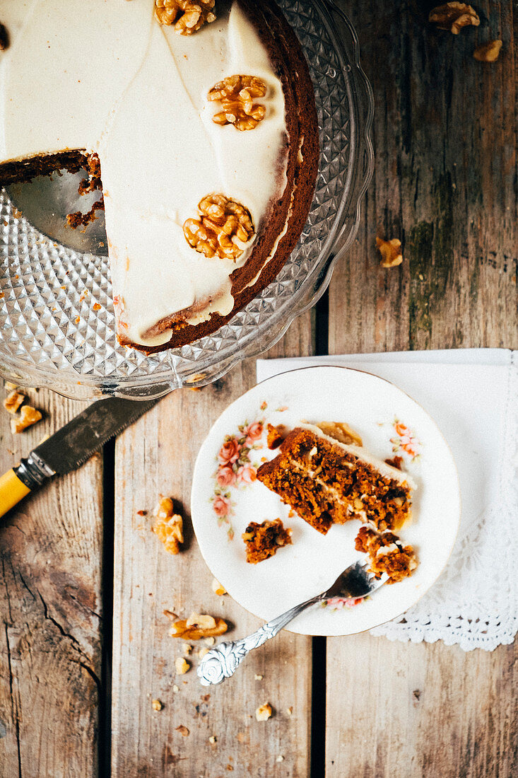 Carrot cake with walnuts on a wooden table with a little vintage plate