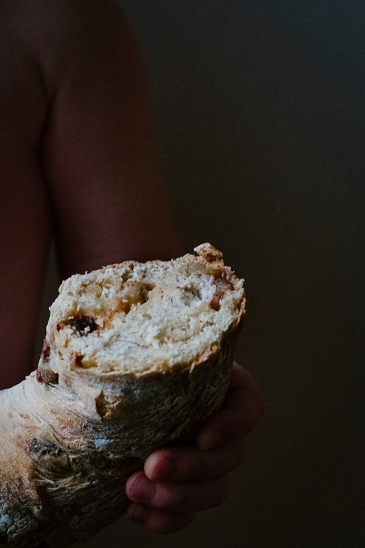 Child holding bread with raisins