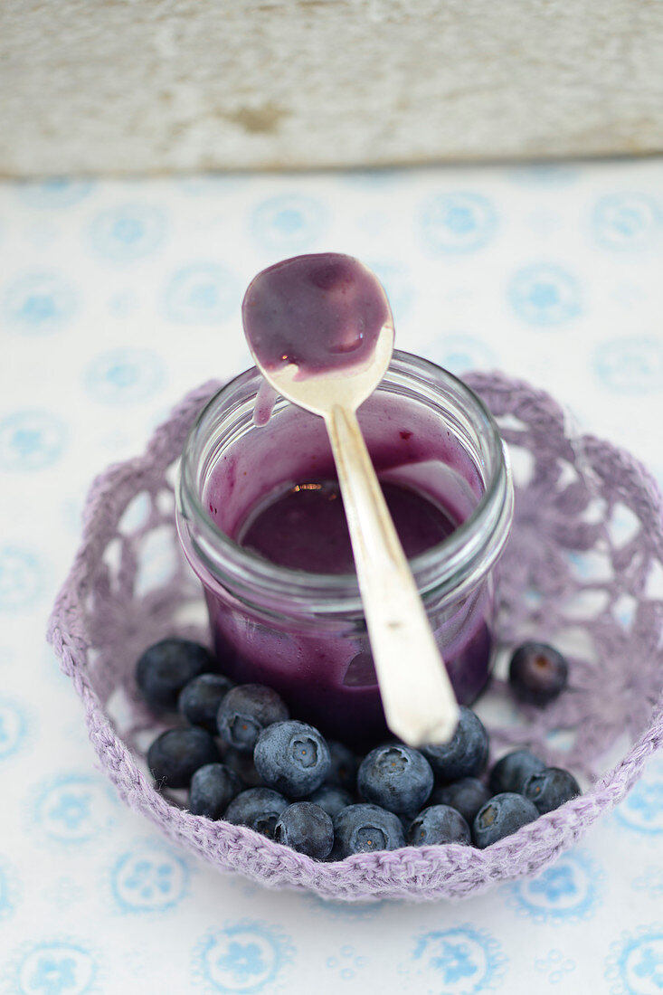 Blueberry curd in a glass with a spoon