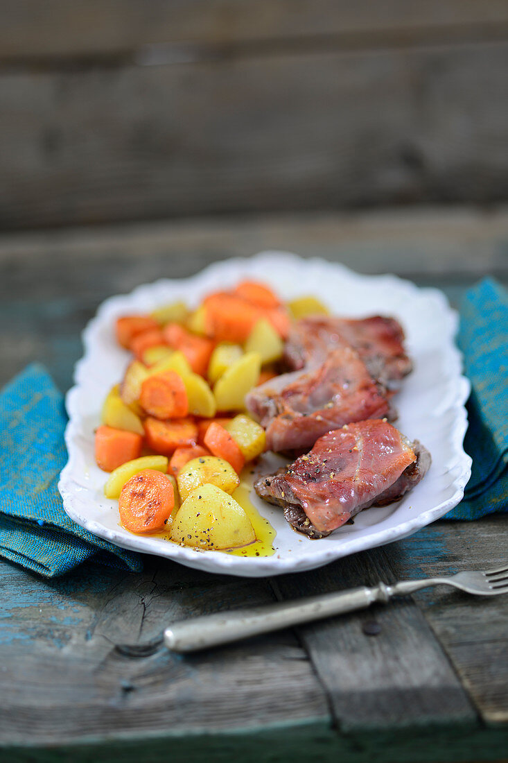 Pork loin with bacon and mixed carrots and potatoes