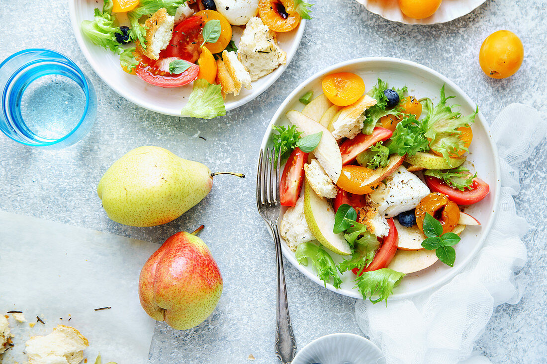 Panzanella salad with mozzarella, toasted baguette, tomatoes and plums