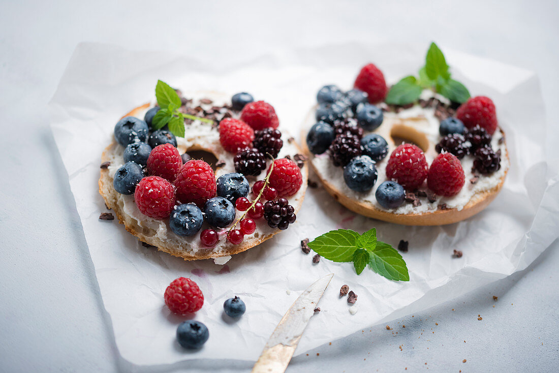 Bagel, belegt mit veganem Quark, frischen Beeren und Kakaonibs