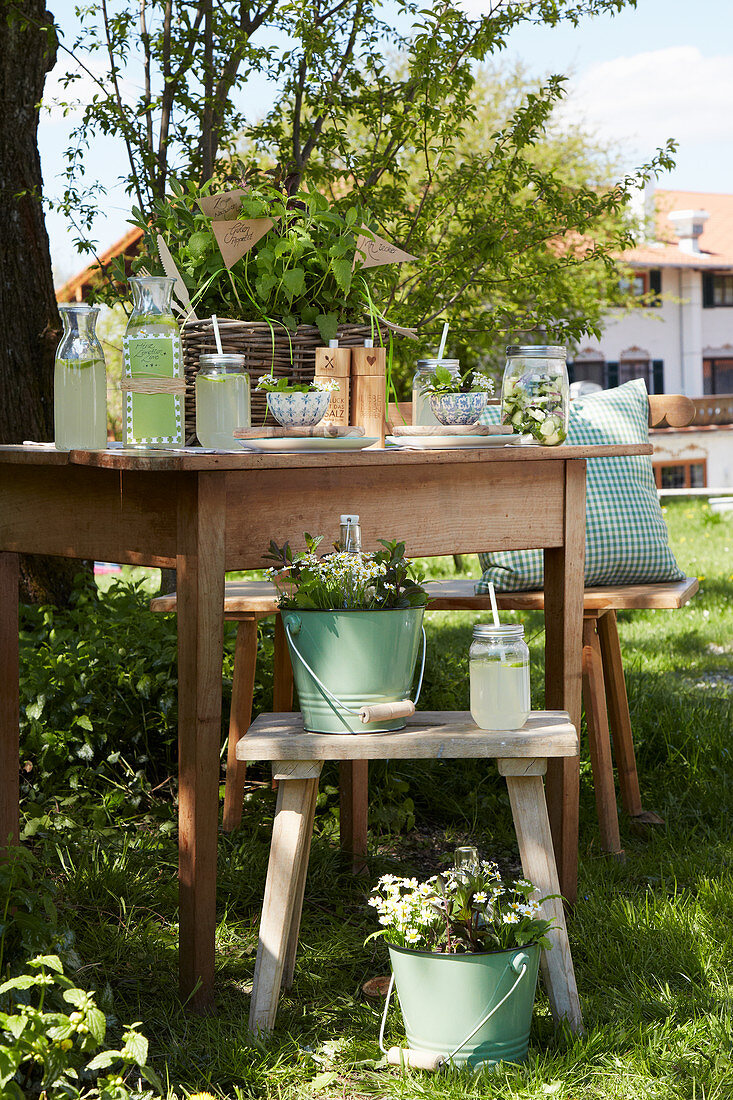 Drinks for garden party on wooden table and stools