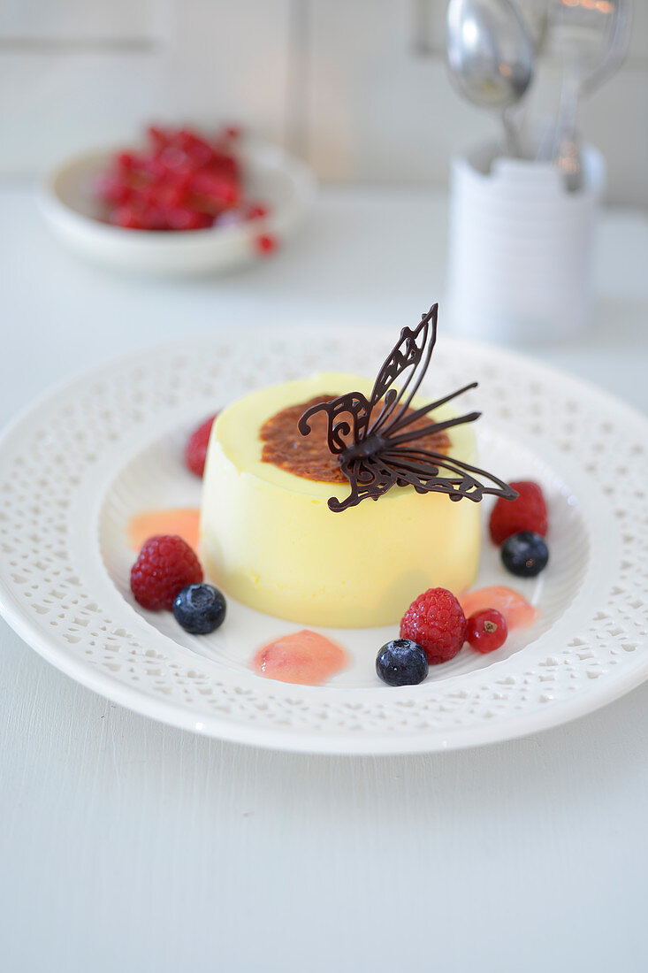 Quark tart with a chocolate butterfly and berries
