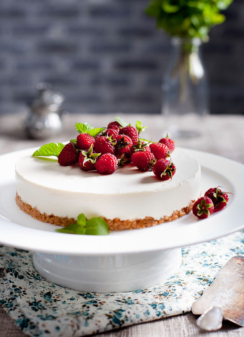 Ziegenkäsekuchen mit frischen Himbeeren und Minzblättchen