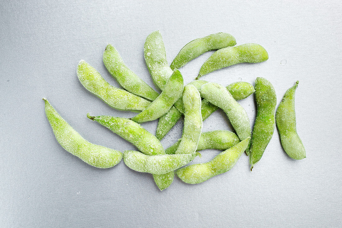 Frozen edamame on a grey background (top view)