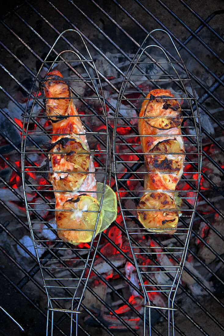Salmon steaks in fish grills over a fire (top view)