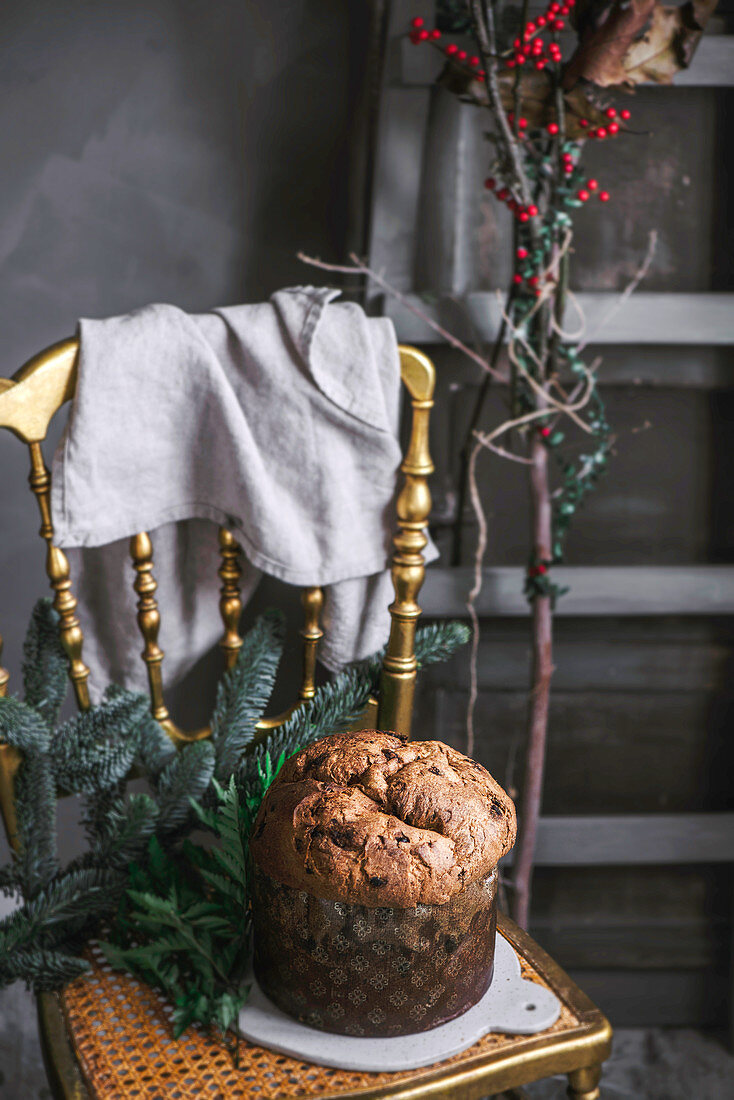 Tasty baked Panettone and two cups placed on chair