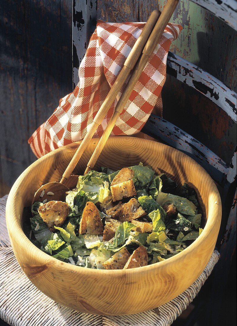 Caesar Salad in a Wooden Bowl; Chair