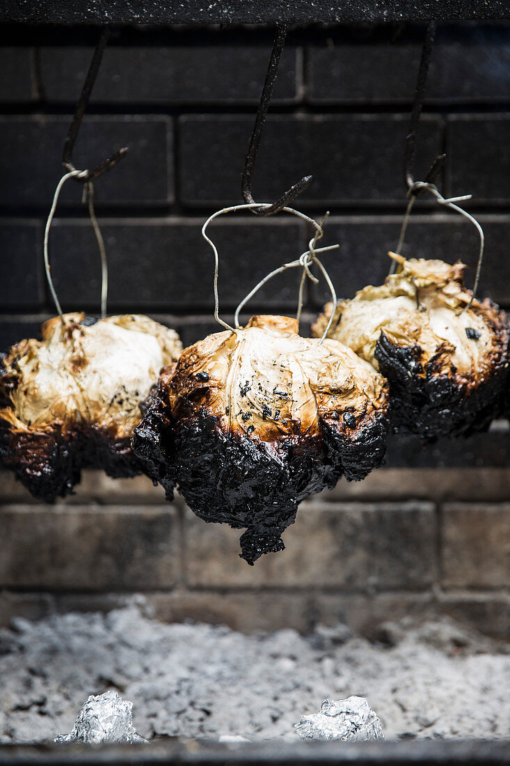 Gegrillte Kohlköpfe über Feuerstelle