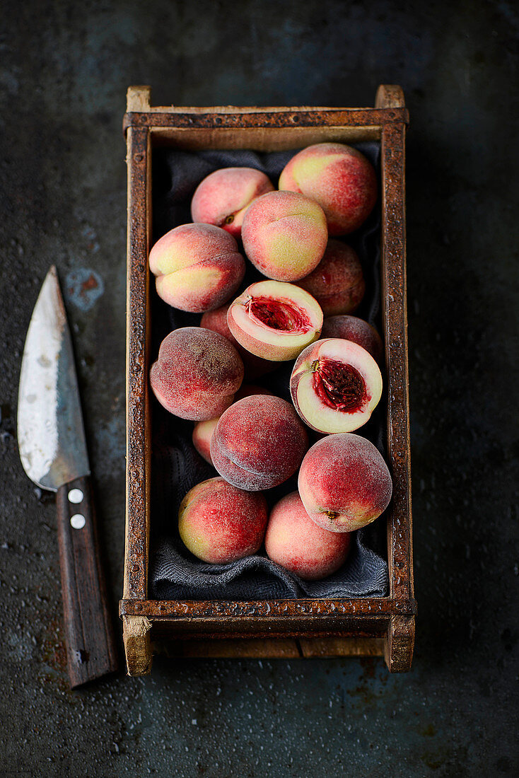 Fresh small peaches in a wooden box