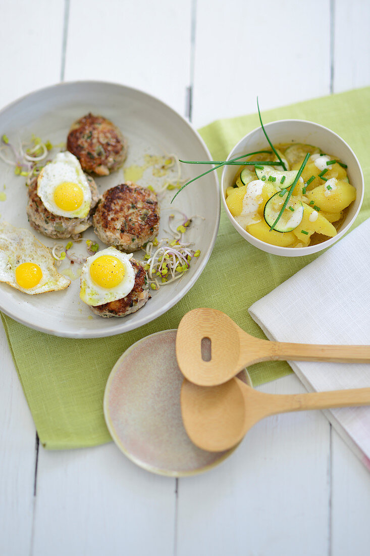 Minced meat and prawn fritters on a courgette and potato salad