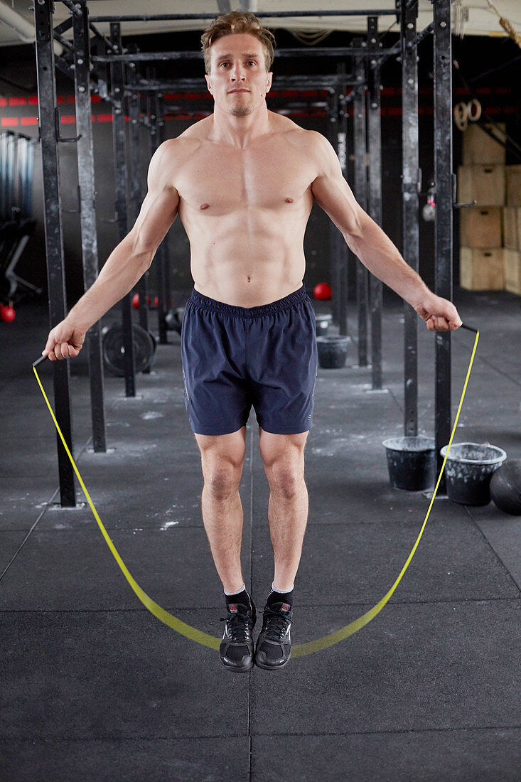 A young man performing double unders with a skipping rope