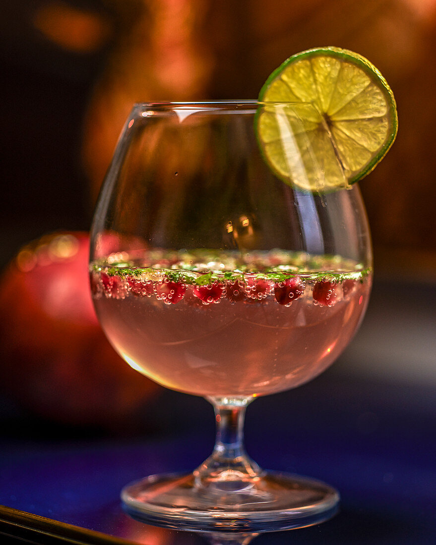 A cocktail with vodka, lemon juice, pomegranate and cilantro