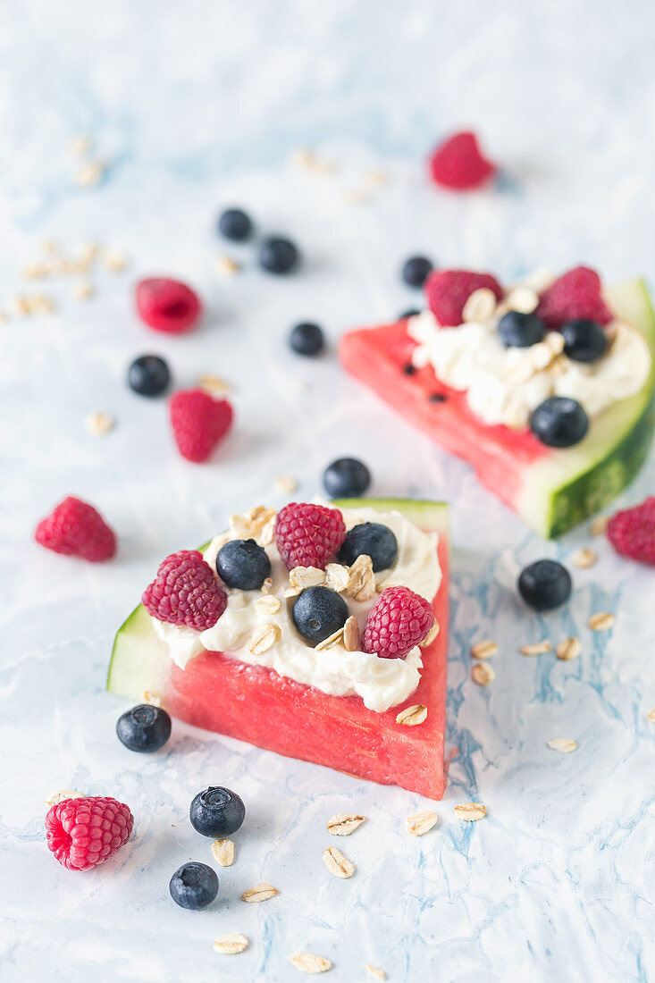 Watermelon slices with whipped cream and fresh berries