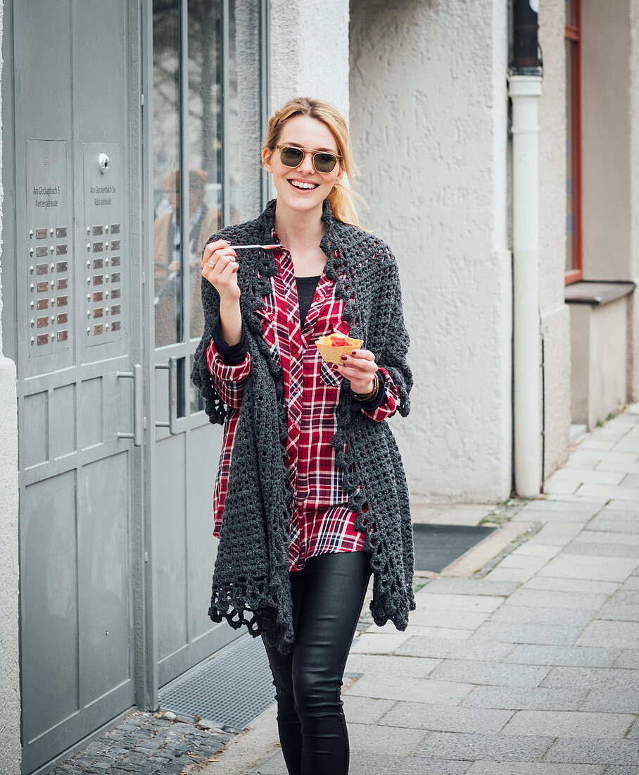 A blonde woman wearing a hand-crocheted, lace-look scarf