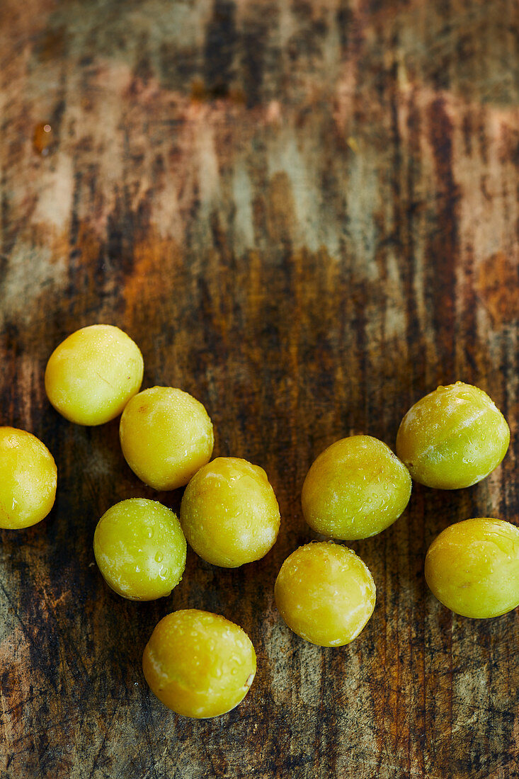 Fresh yellow plums on a wooden surface