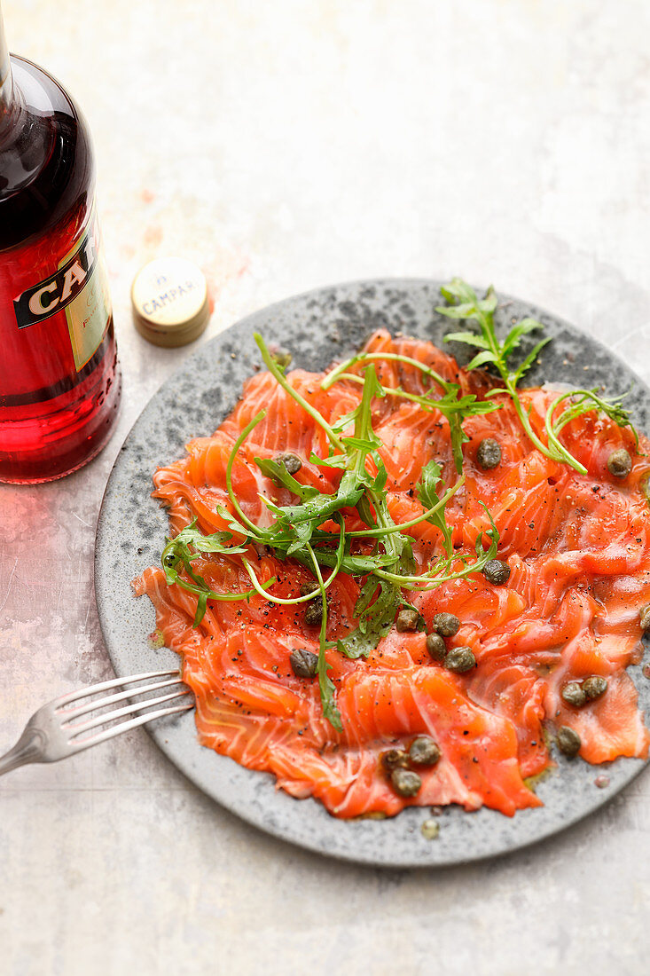 Salmon carpaccio with capers and campari dressing