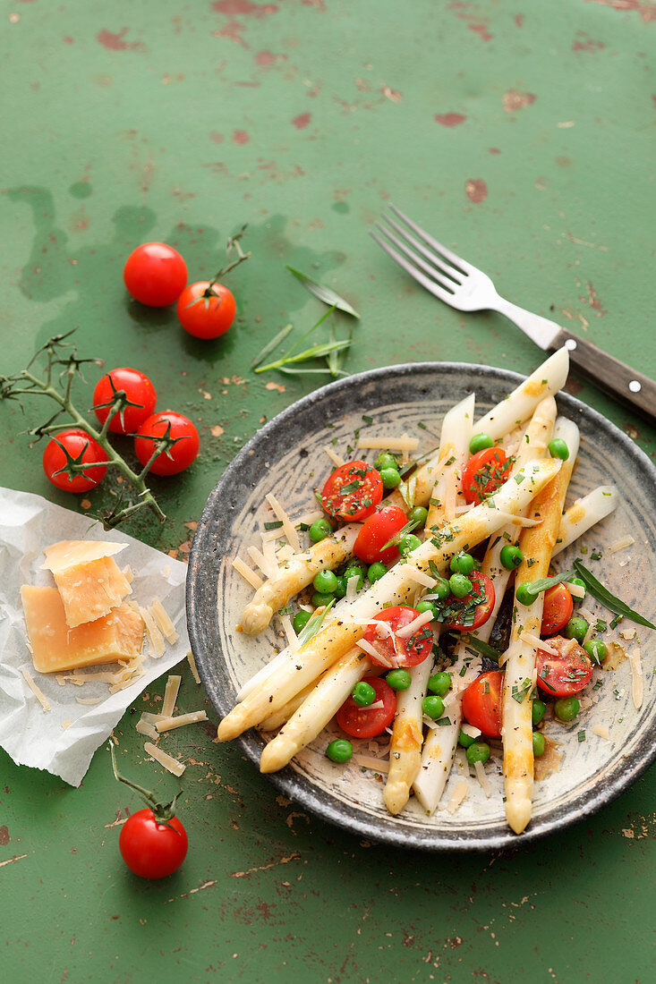 White asparagus salad with tomatoes, peas and parmesan
