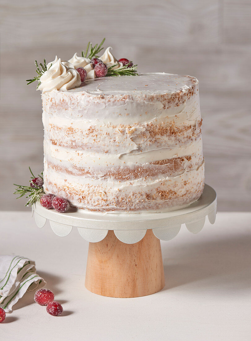 Wintery white layer cake with a cream filling on a cake stand