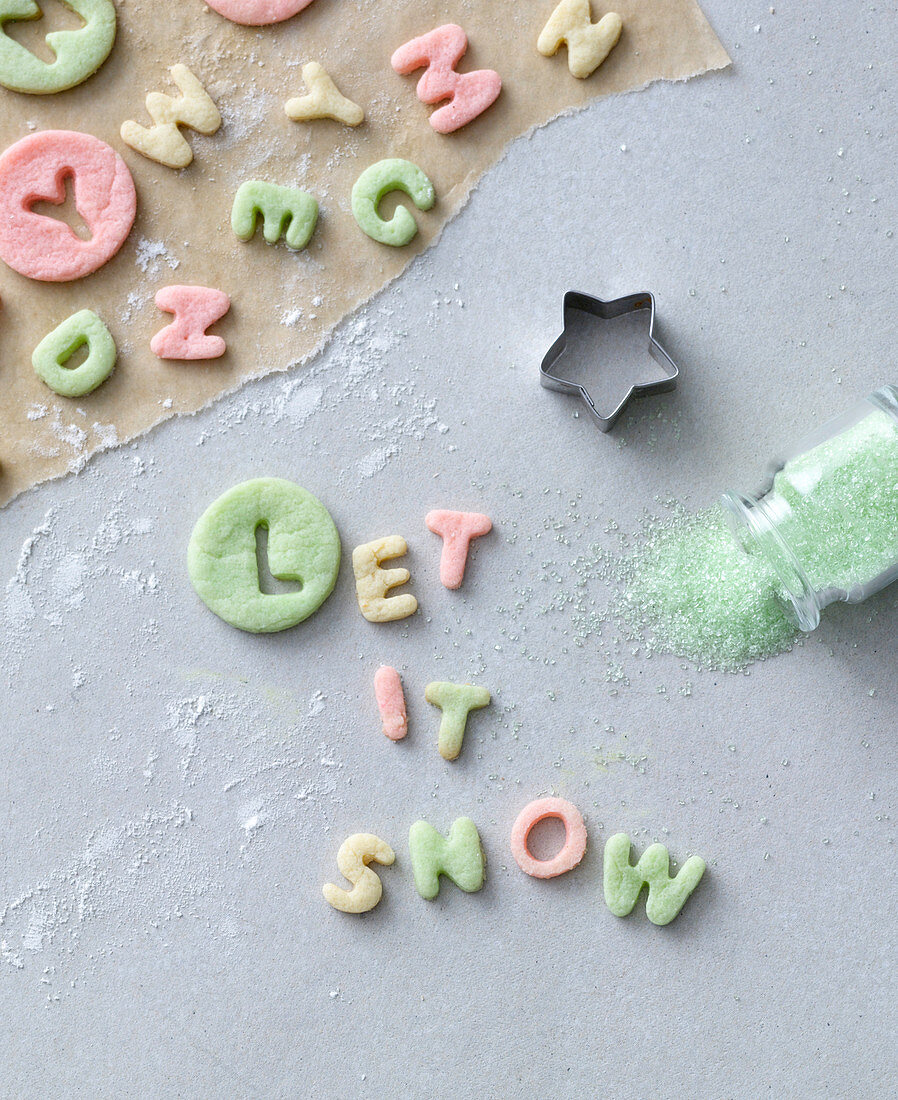 Schriftzug 'Let it snow' aus ausgestochenen bunten Teig-Buchstaben