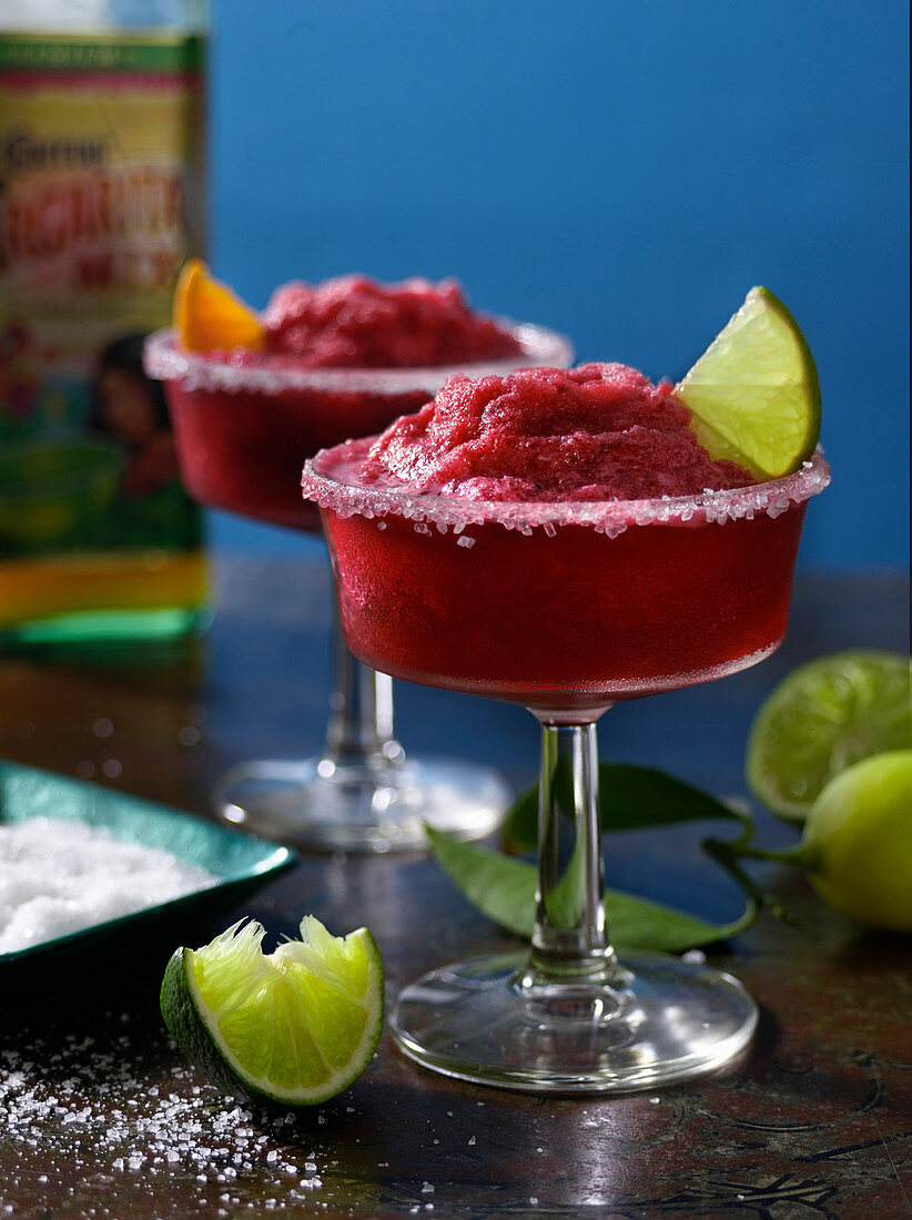 Two Margaritas with a sugar rim and limes