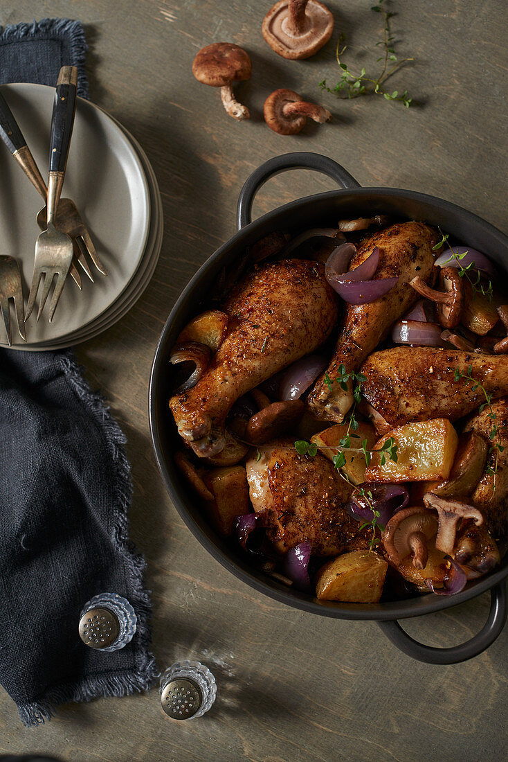 Chicken with potatoes, mushrooms and red onions in a roasting tin