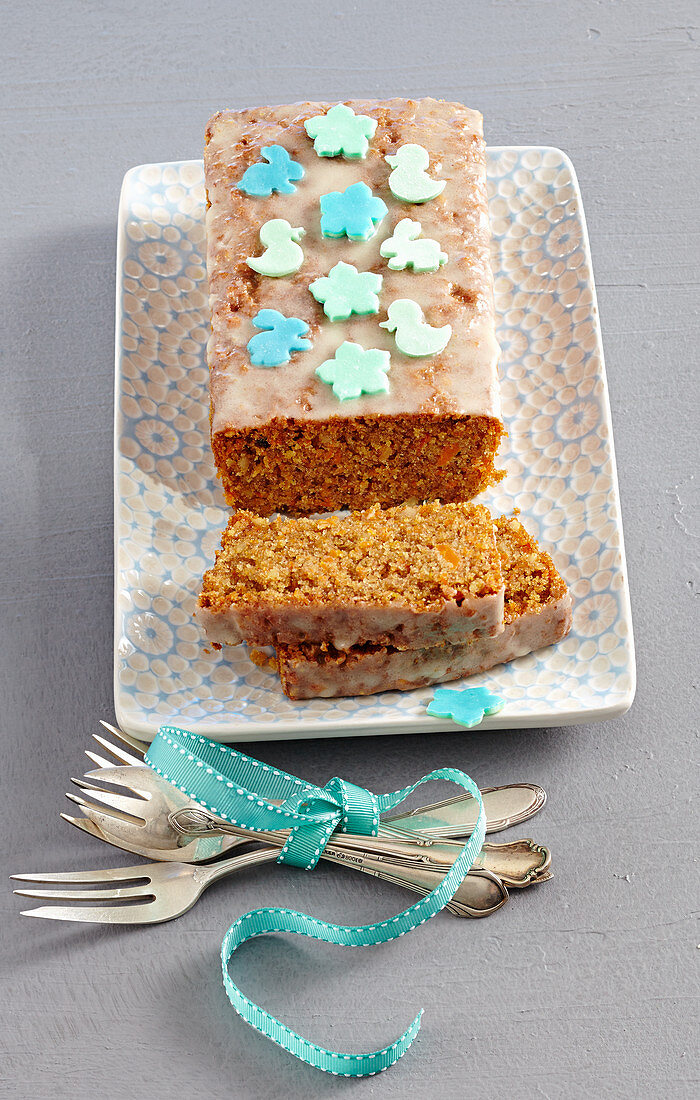 A carrot loaf cake decorated with icing and fondant animals