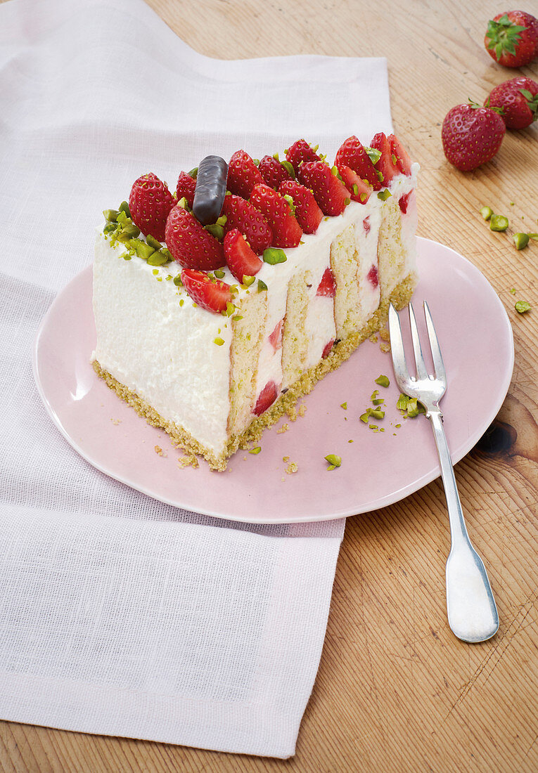 A piece of fresh strawberry cake with chopped pistachios
