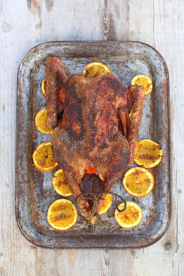A stuffed grilled goose with peppered oranges