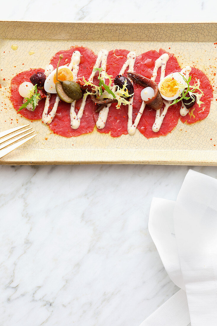 Beef carpaccio with capers, quail eggs and lemon sauce