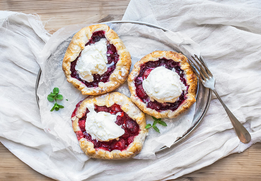 Rustic small galeta pies with fresh berries and vanilla ice-cream