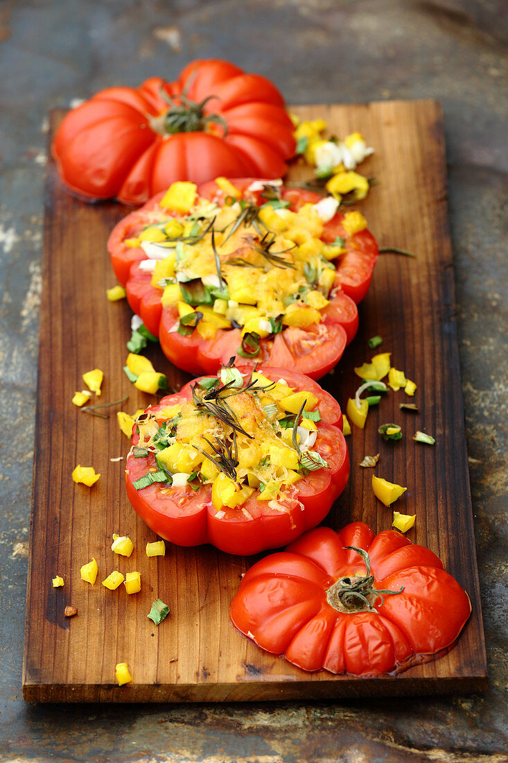 Grilled stuffed tomatoes with black cherry balsamic on a wooden board