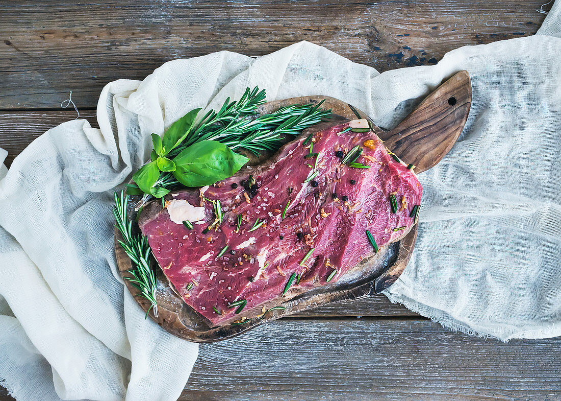 A piece of raw fresh beef (Ribeye steak) marinated in spices and herbs